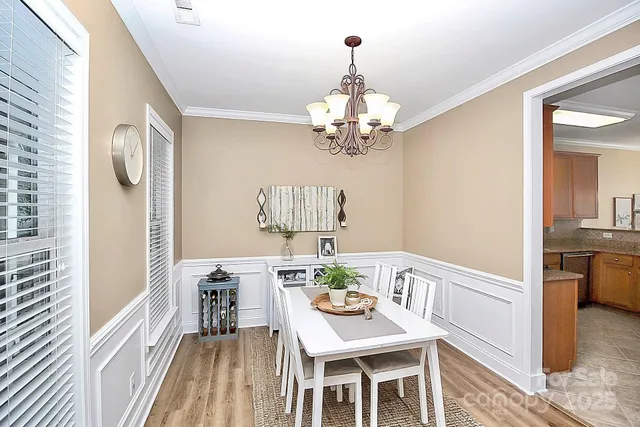 a view of a dining room with furniture a chandelier and wooden floor
