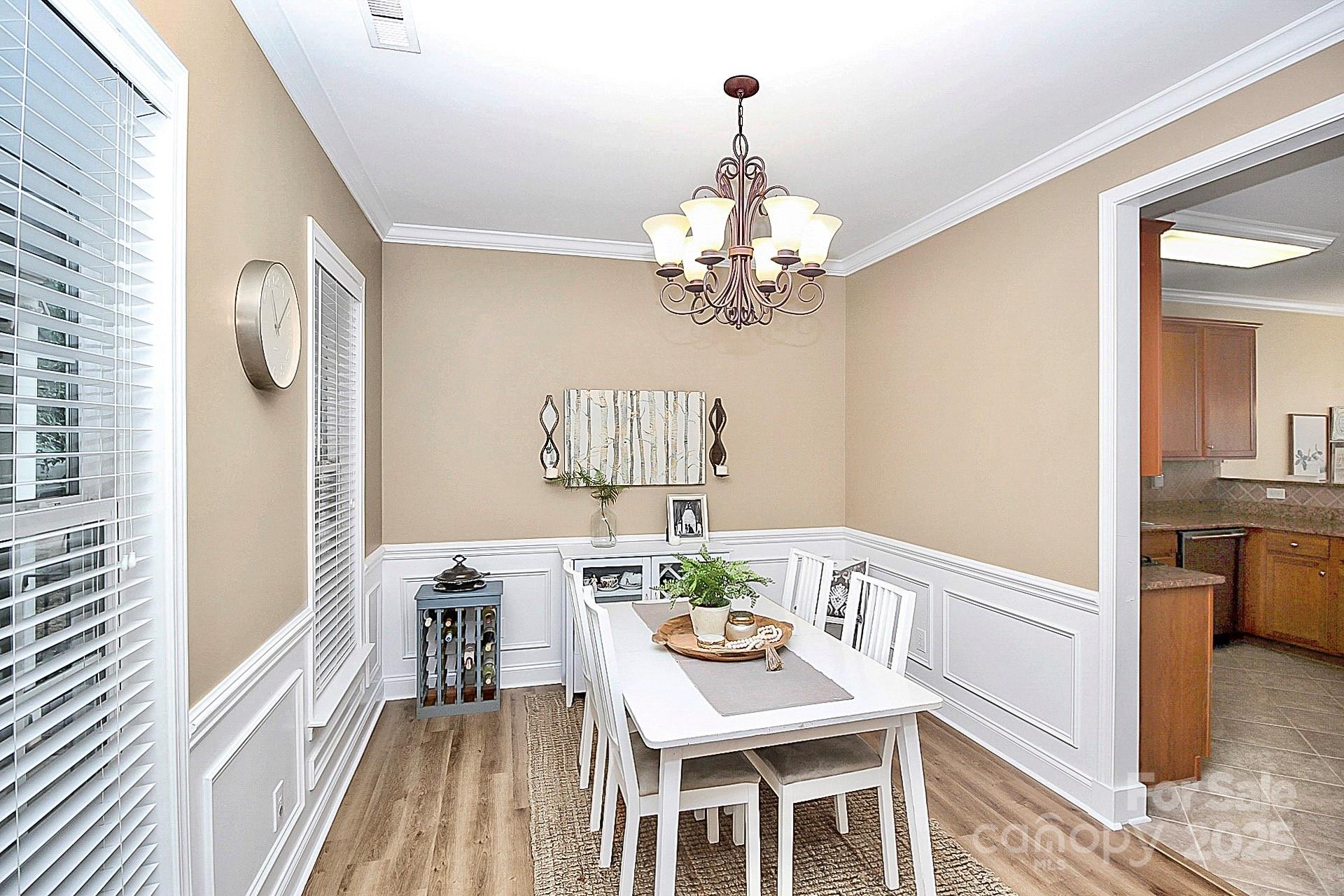 10008 Caldwell Depot Road Cornelius, NC 28031 - Photo 7 of 33 a view of a dining room with furniture a chandelier and wooden floor