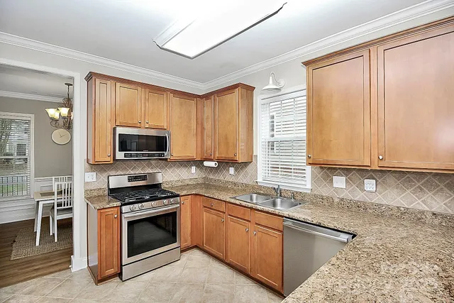 a kitchen with stainless steel appliances granite countertop a stove a sink and a microwave