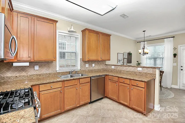 a kitchen with stainless steel appliances granite countertop wooden cabinets a sink and a window