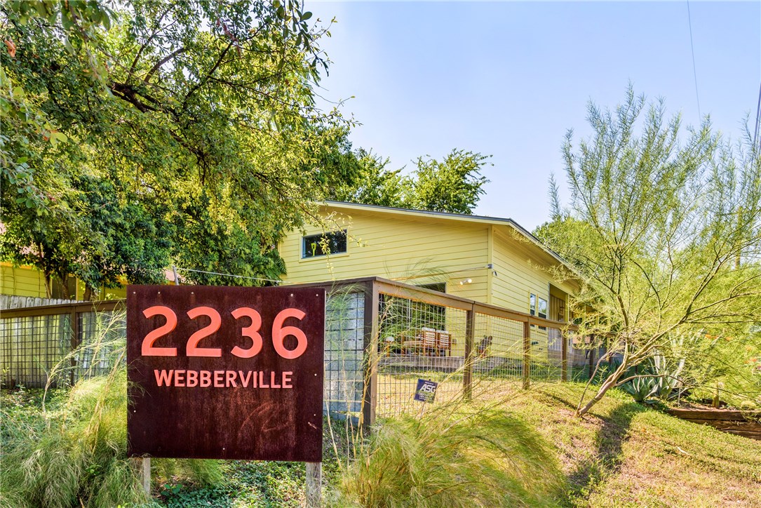 a view of a sign board with large trees