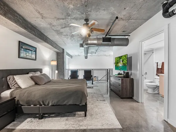 a bedroom with a bed couch and white walls