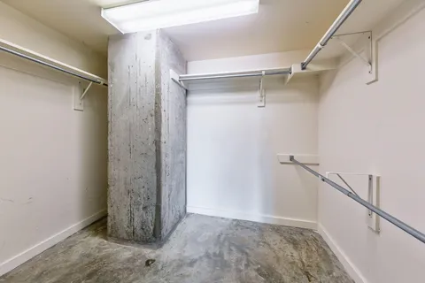 a view of walk in closet with empty racks
