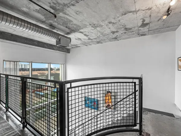 a view of staircase with railing and a rug
