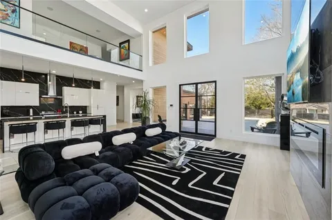 a living room with furniture a flat screen tv and a table