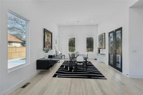 a kitchen with stainless steel appliances kitchen island granite countertop a stove a refrigerator a sink a dining table and chairs with wooden floor