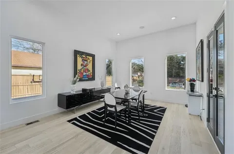 a kitchen with stainless steel appliances kitchen island hardwood floor sink stove dining table and chairs