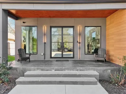 a living room with a floor to ceiling window and potted plants