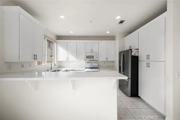 a kitchen with granite countertop white cabinets and white appliances