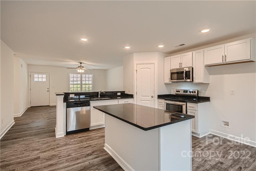 1901 Collins Drive Albemarle, NC 28001 - Photo 4 of 11 a kitchen with stainless steel appliances granite countertop a sink stove and refrigerator