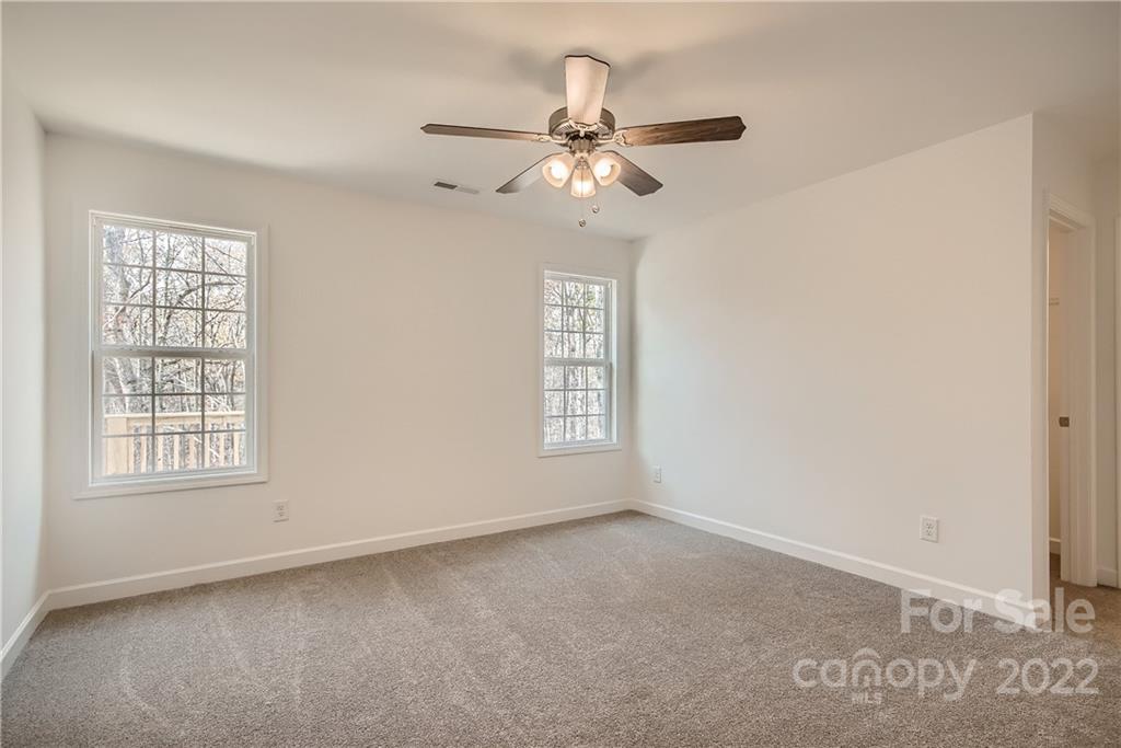 1901 Collins Drive Albemarle, NC 28001 - Photo 5 of 11 an empty room with chandelier fan and windows