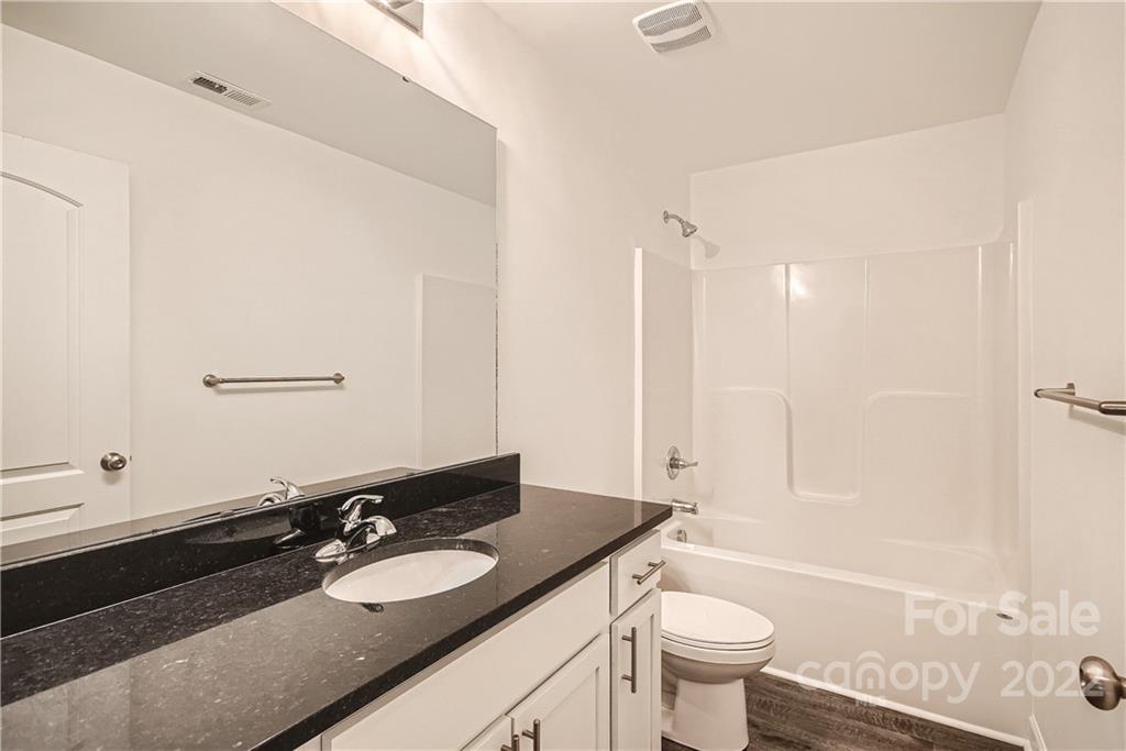 1901 Collins Drive Albemarle, NC 28001 - Photo 8 of 11 a bathroom with a granite countertop sink toilet a mirror and shower