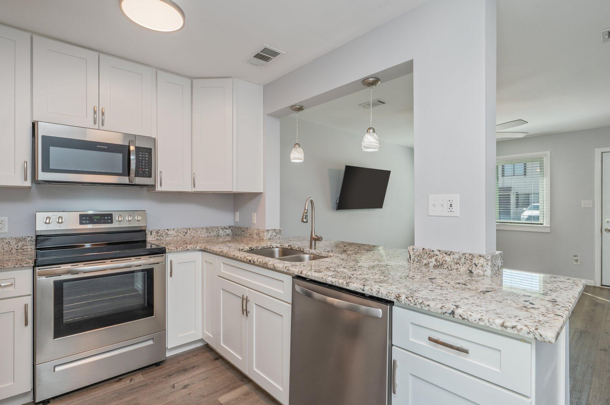 710 Legion Drive Destin, FL 32541 - Photo 1 of 29 a kitchen with granite countertop a stove top oven microwave and cabinets