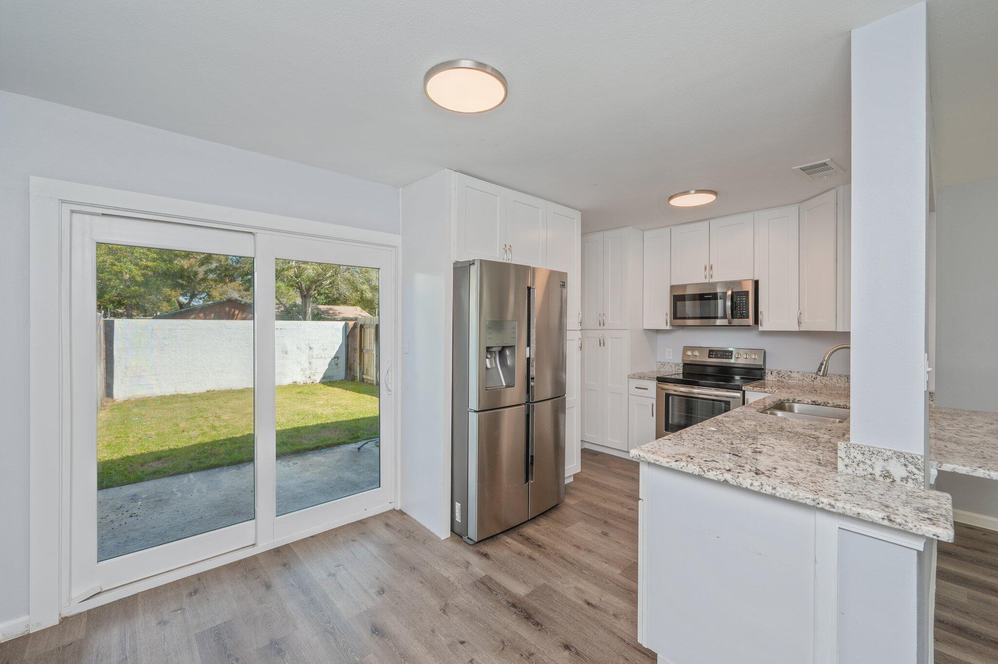 710 Legion Drive Destin, FL 32541 - Photo 11 of 29 a kitchen with granite countertop a refrigerator and a stove top oven