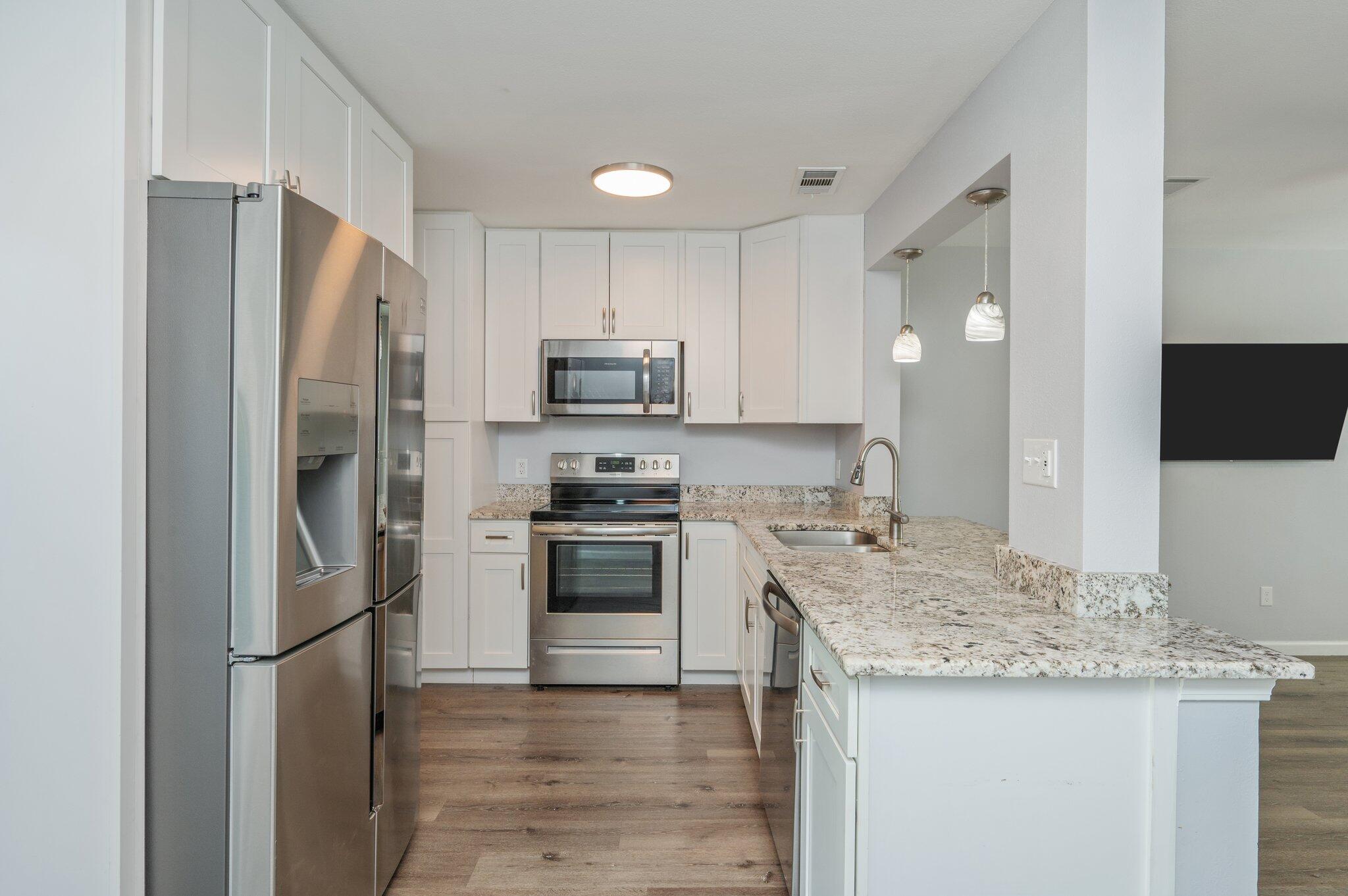 710 Legion Drive Destin, FL 32541 - Photo 12 of 29 a kitchen with stainless steel appliances granite countertop a refrigerator stove and sink
