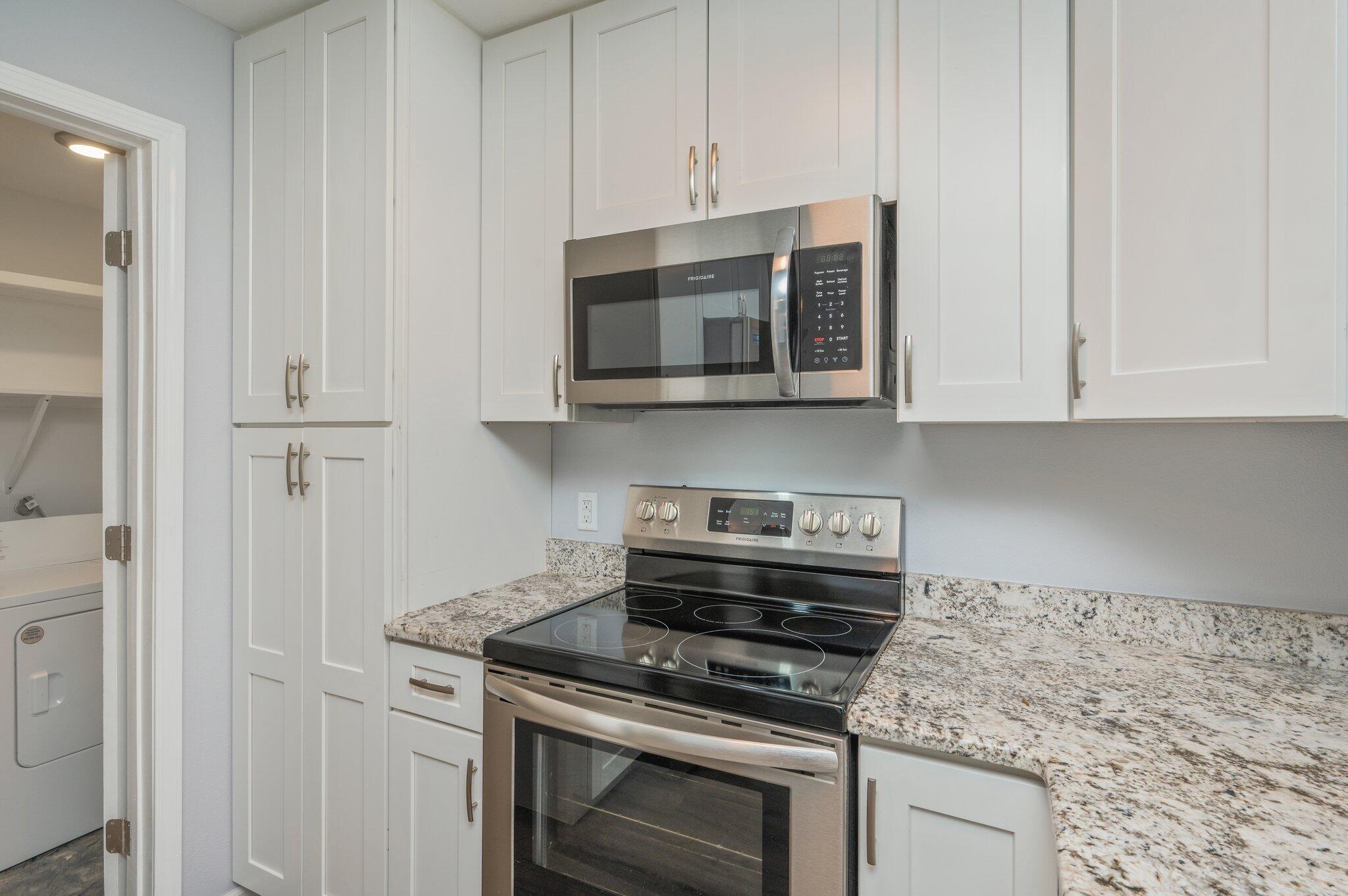 710 Legion Drive Destin, FL 32541 - Photo 15 of 29 a kitchen with stainless steel appliances granite countertop white cabinets and a stove top oven