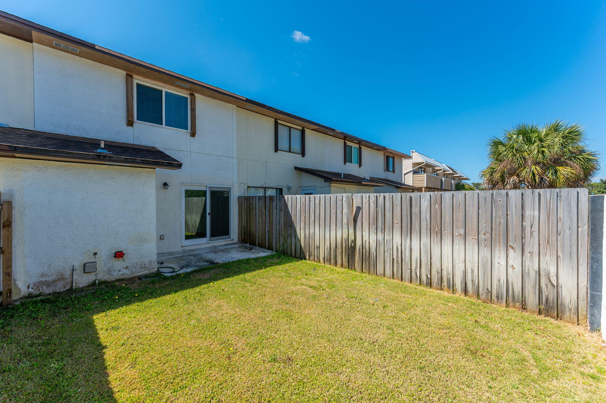 710 Legion Drive Destin, FL 32541 - Photo 27 of 29 a view of a backyard with plants and wooden fence