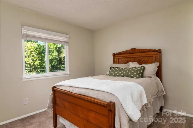 a bed sitting in a bedroom next to a window