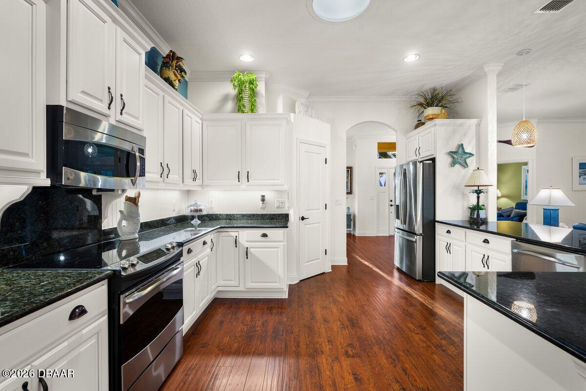 4767 Riverglen Boulevard Ponce Inlet, FL 32127 - Photo 32 of 60 a large kitchen with stainless steel appliances and wooden cabinets