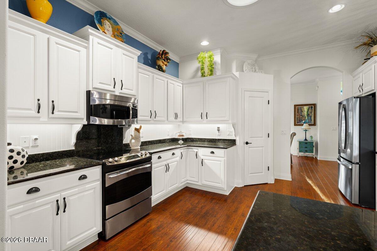 4767 Riverglen Boulevard Ponce Inlet, FL 32127 - Photo 33 of 60 a kitchen with stainless steel appliances granite countertop a stove a sink and a refrigerator