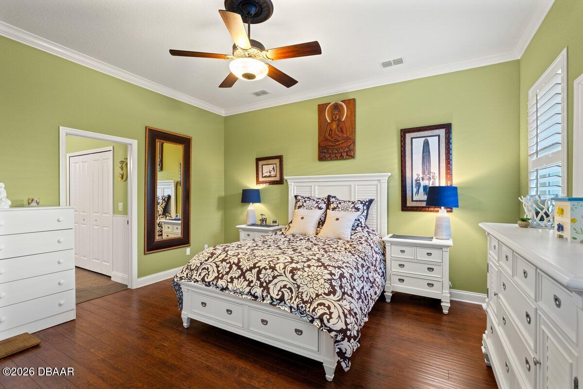 4767 Riverglen Boulevard Ponce Inlet, FL 32127 - Photo 44 of 60 a bedroom with a bed and a chandelier