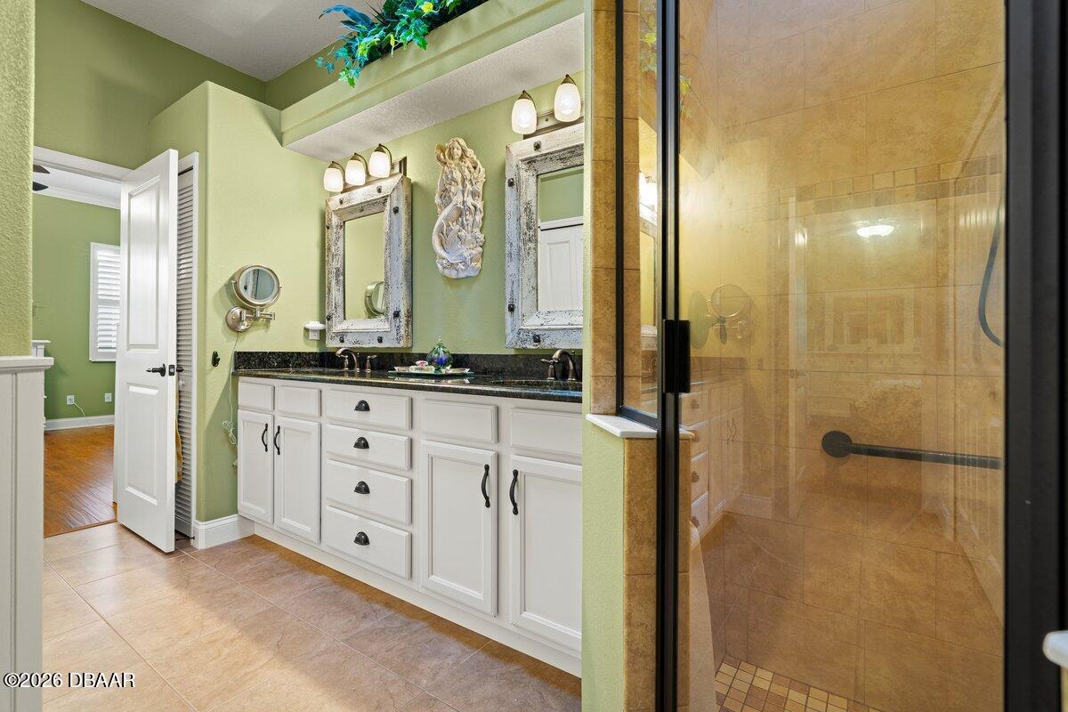 4767 Riverglen Boulevard Ponce Inlet, FL 32127 - Photo 47 of 60 a spacious bathroom with a granite countertop sink mirror and a shower