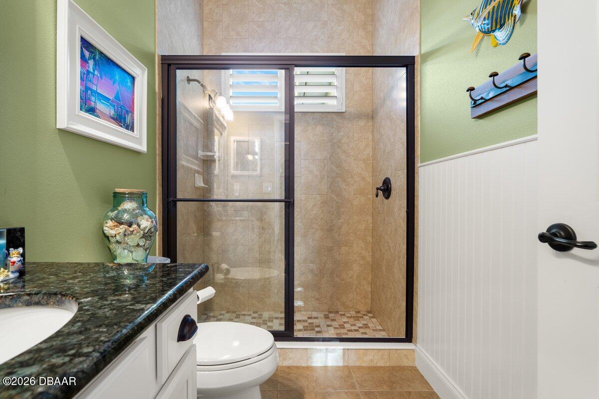 4767 Riverglen Boulevard Ponce Inlet, FL 32127 - Photo 53 of 60 a bathroom with a granite countertop sink toilet and shower