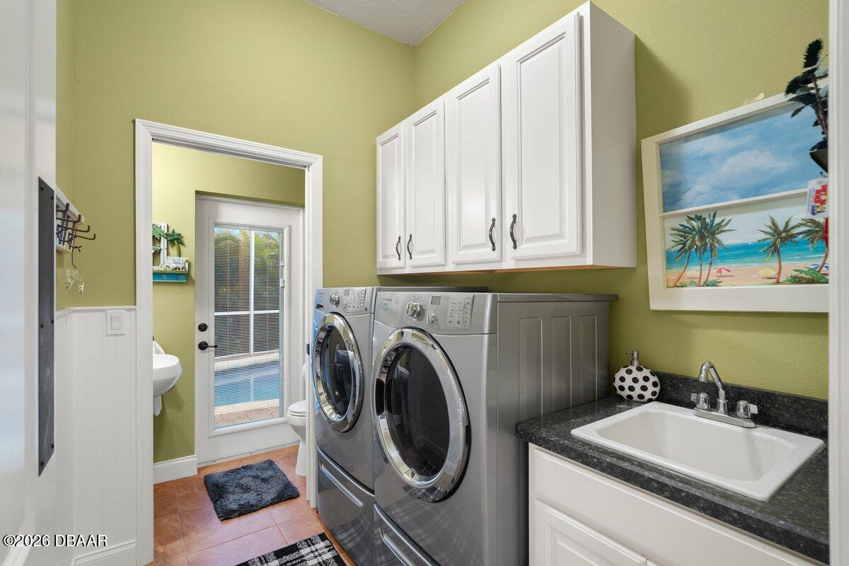 4767 Riverglen Boulevard Ponce Inlet, FL 32127 - Photo 57 of 60 a bathroom with a sink a washer and dryer