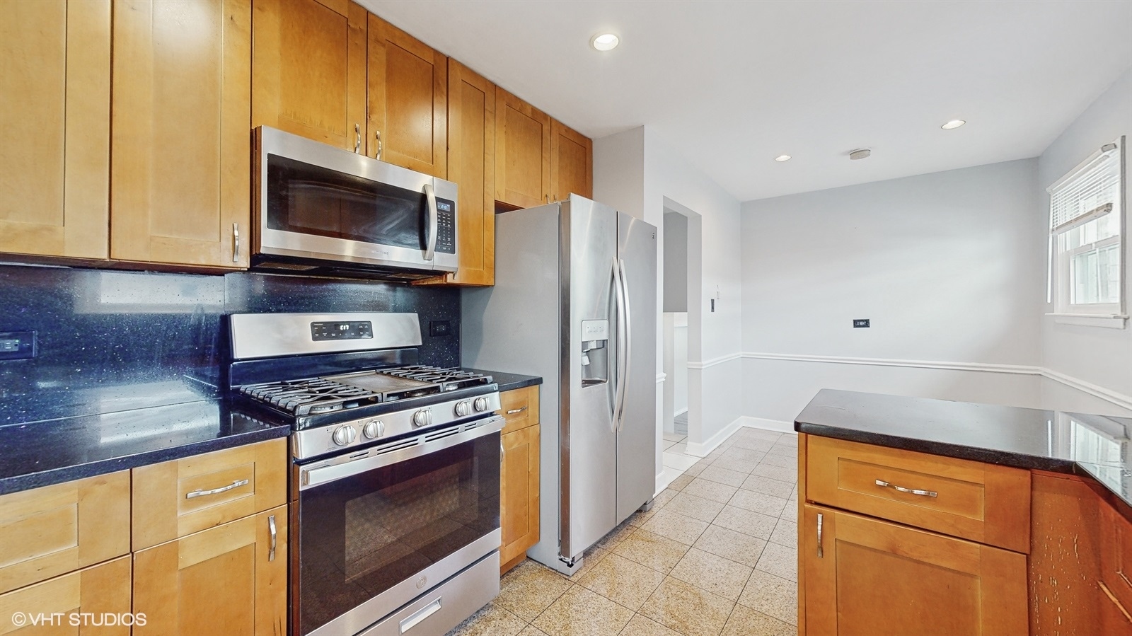 7700 Maple Street Morton Grove, IL 60053 - Photo 11 of 43 a kitchen with stainless steel appliances granite countertop a stove microwave and refrigerator