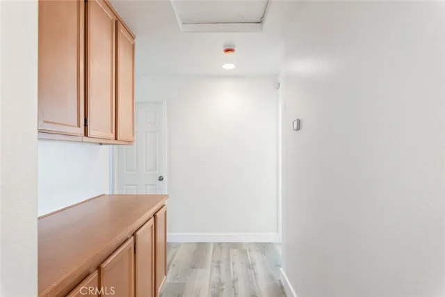 a view of a kitchen with white cabinets and wooden floor