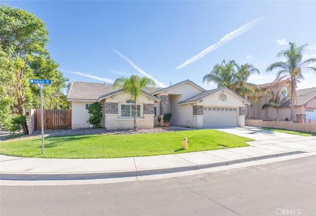 a house with a yard and a car park in front of it