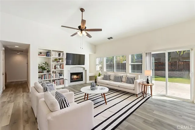 a living room with furniture a fireplace and a floor to ceiling window