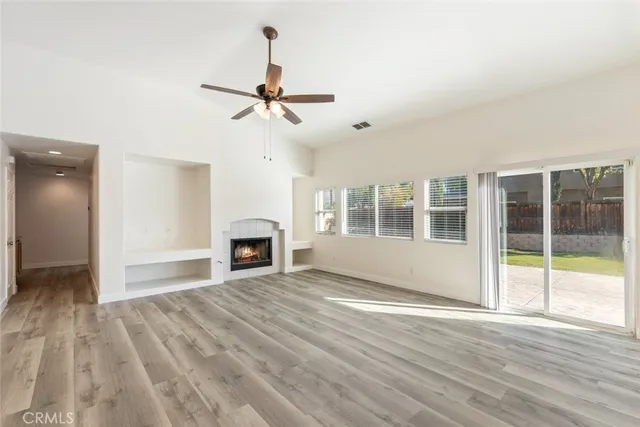 a view of empty room with wooden floor and fireplace