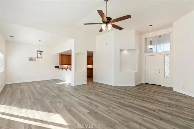 a view of a kitchen with wooden floor and a ceiling fan