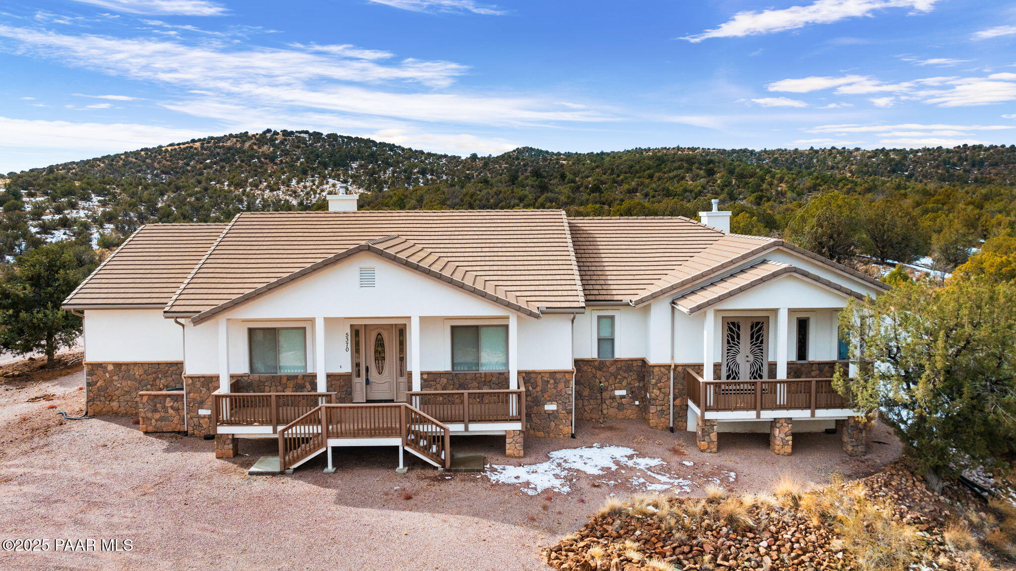 a view of a patio with couches table and chairs under an umbrella
