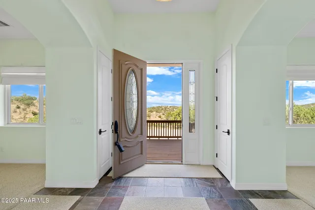a view of a hallway with wooden floor and a livingroom