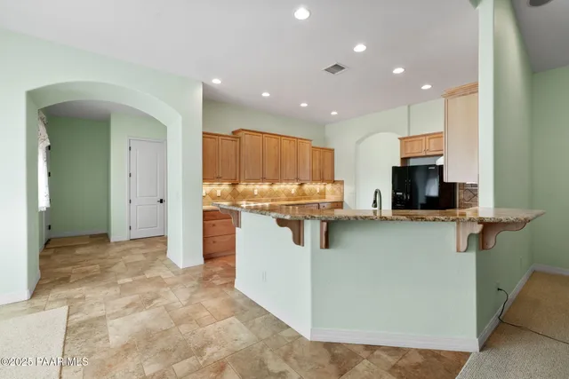a kitchen with stainless steel appliances granite countertop a refrigerator and a stove top oven