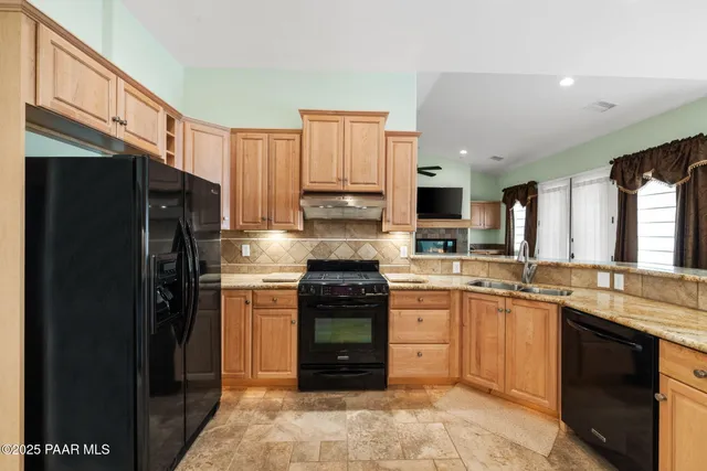 a kitchen with stainless steel appliances granite countertop a stove top oven a refrigerator and a granite counter tops
