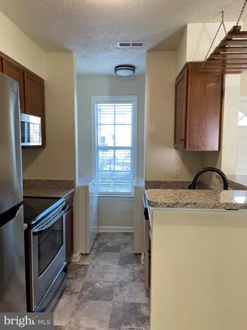 a kitchen with granite countertop a sink stove and cabinets