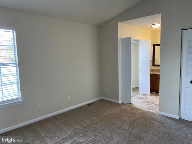 an empty room with windows and closet