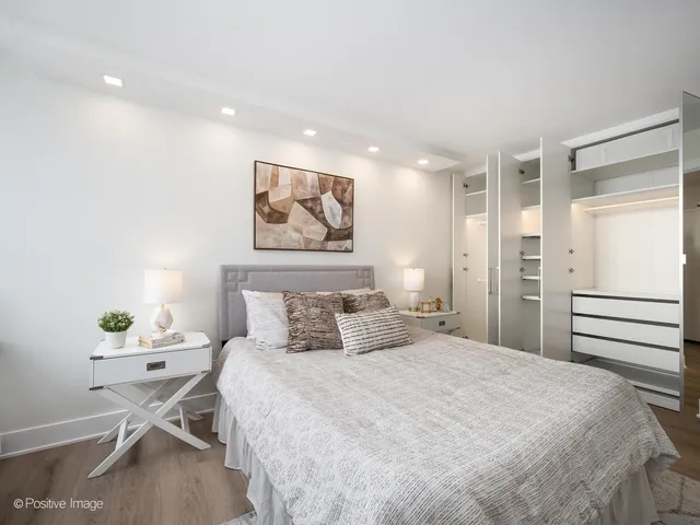 a bedroom with a bed and a painting on the wall