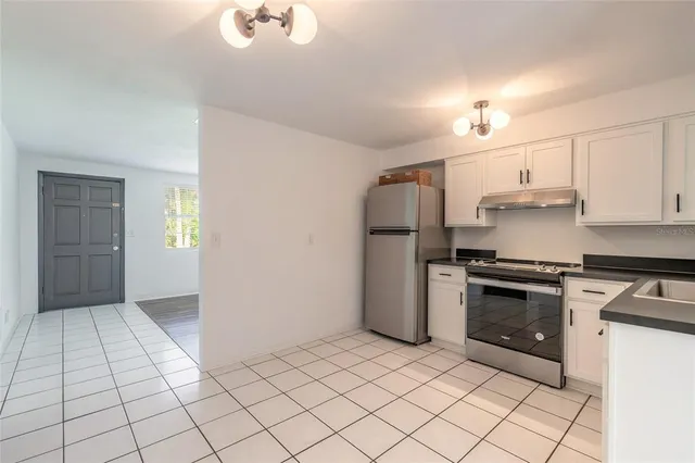a kitchen with granite countertop white cabinets and white appliances