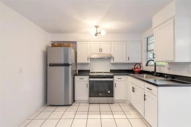 a kitchen with granite countertop a refrigerator and a sink