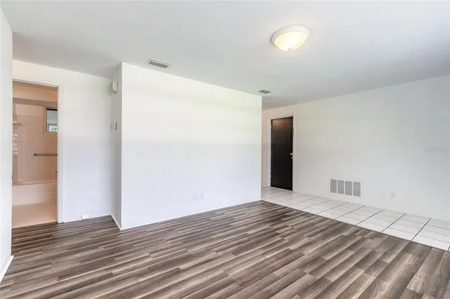 a view of an empty room with wooden floor