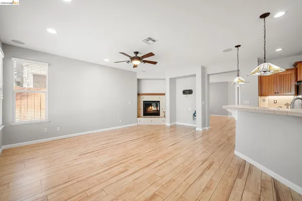 a view of a kitchen with a ceiling fan hardwood floor and a kitchen