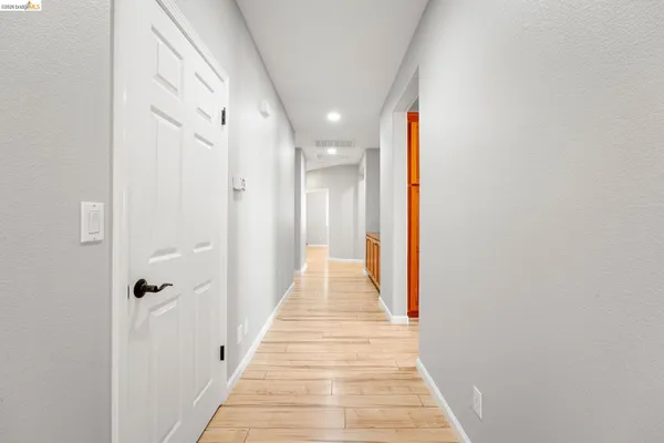 a view of a hallway with wooden floor and staircase