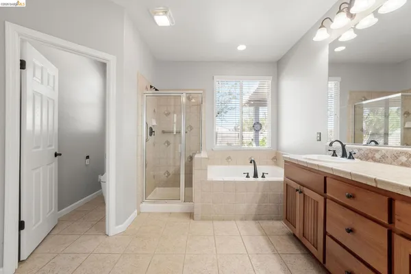 a spacious bathroom with a tub sink shower and mirror