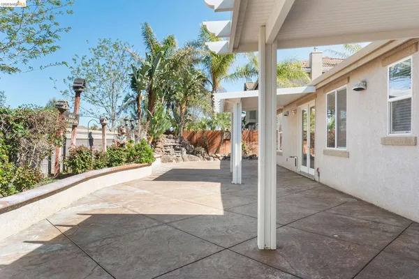 a view of a patio with couches and table and chairs next to yard
