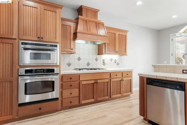 a kitchen with cabinets stainless steel appliances and a sink
