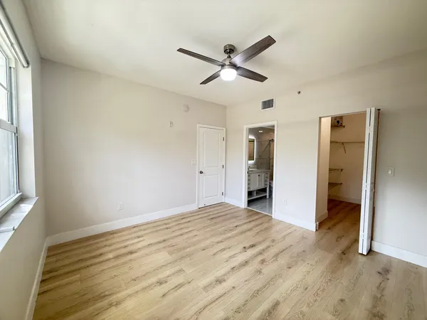 a view of empty room with wooden floor and window